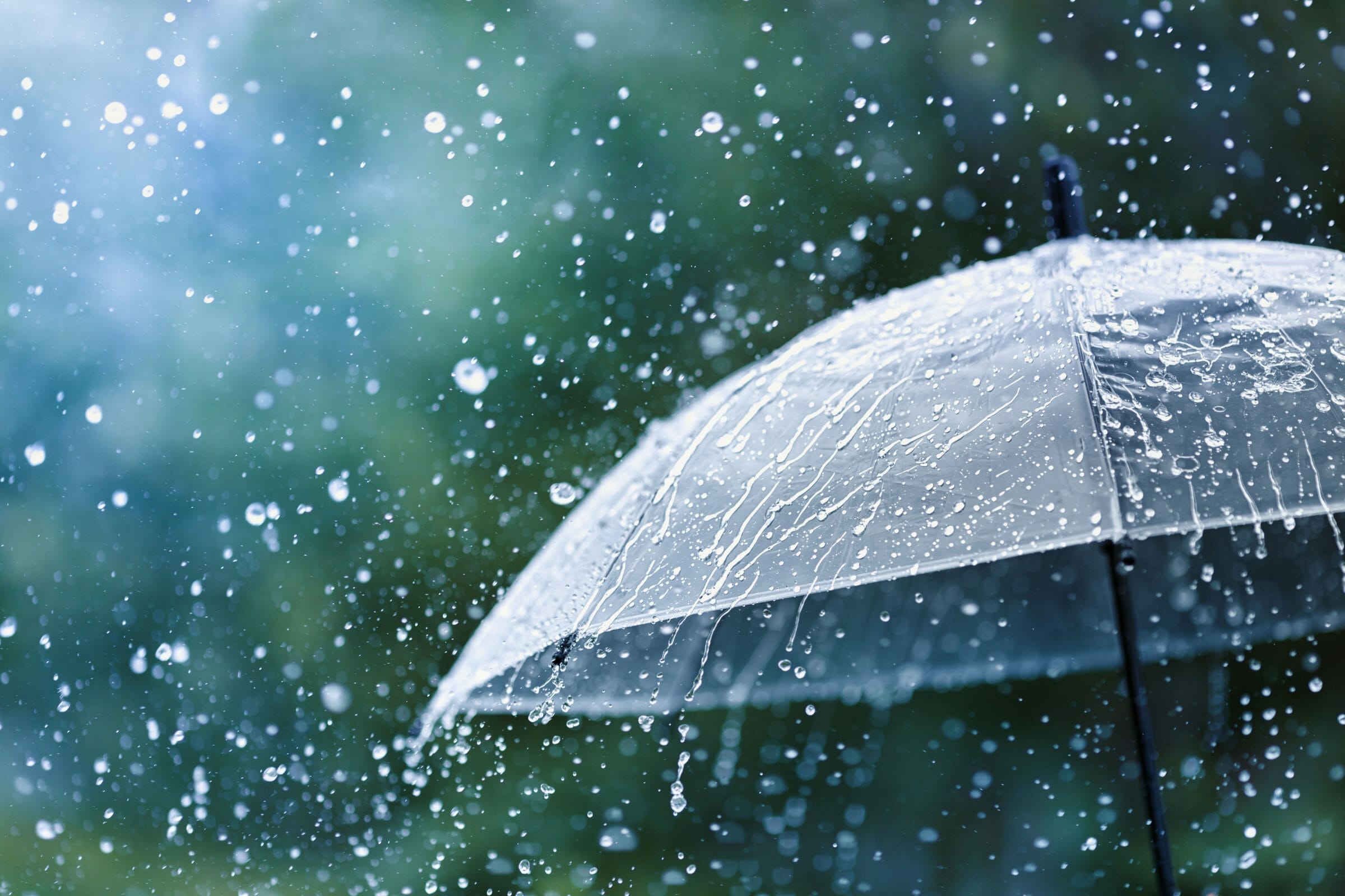 Transparent umbrella under rain against water drops splash background.